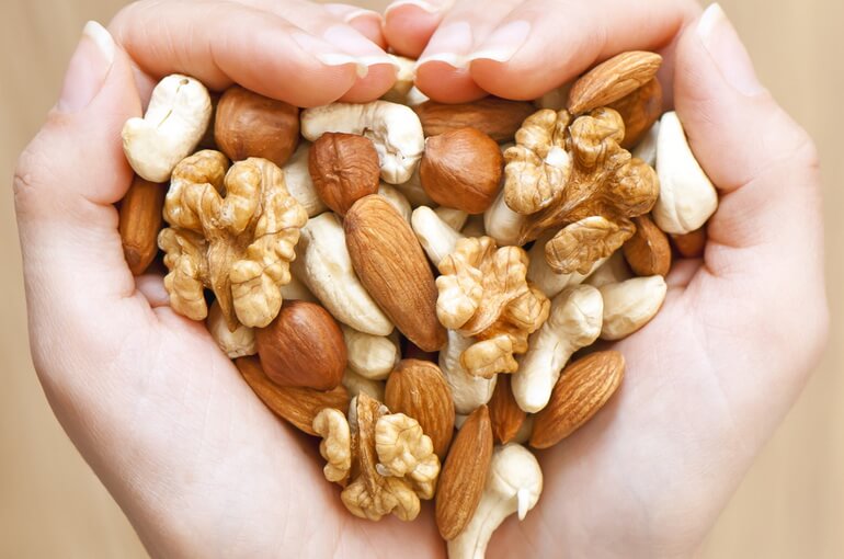 Орехи в руках в виде сердца